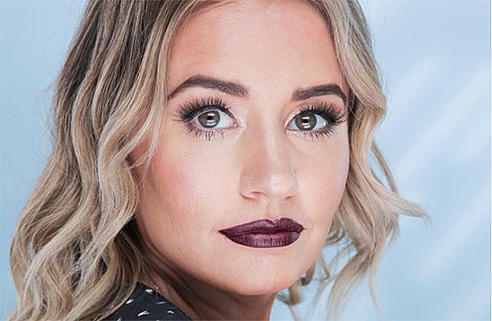 Woman with bold makeup and wavy hair.