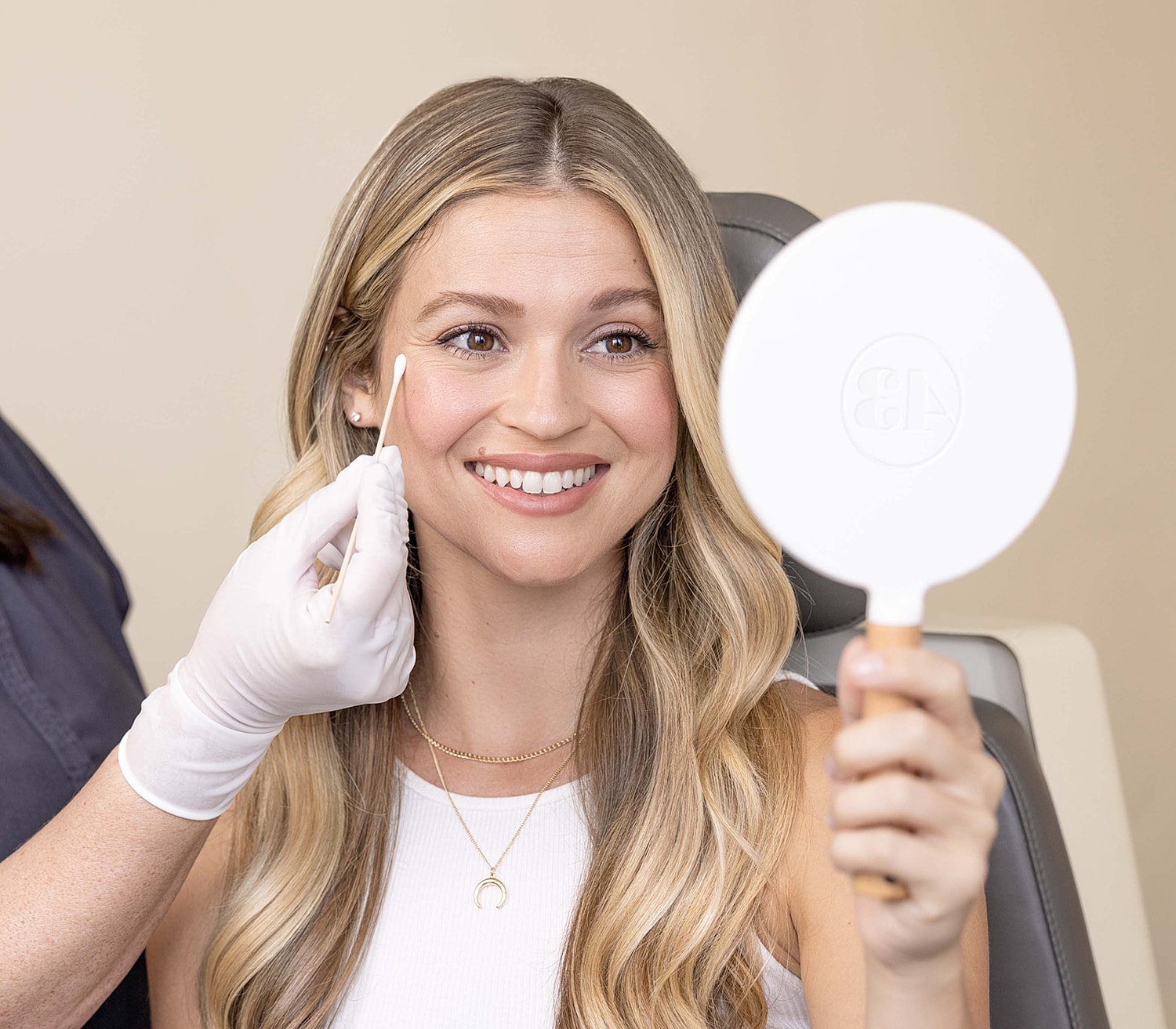 Woman smiling while receiving a facial treatment.