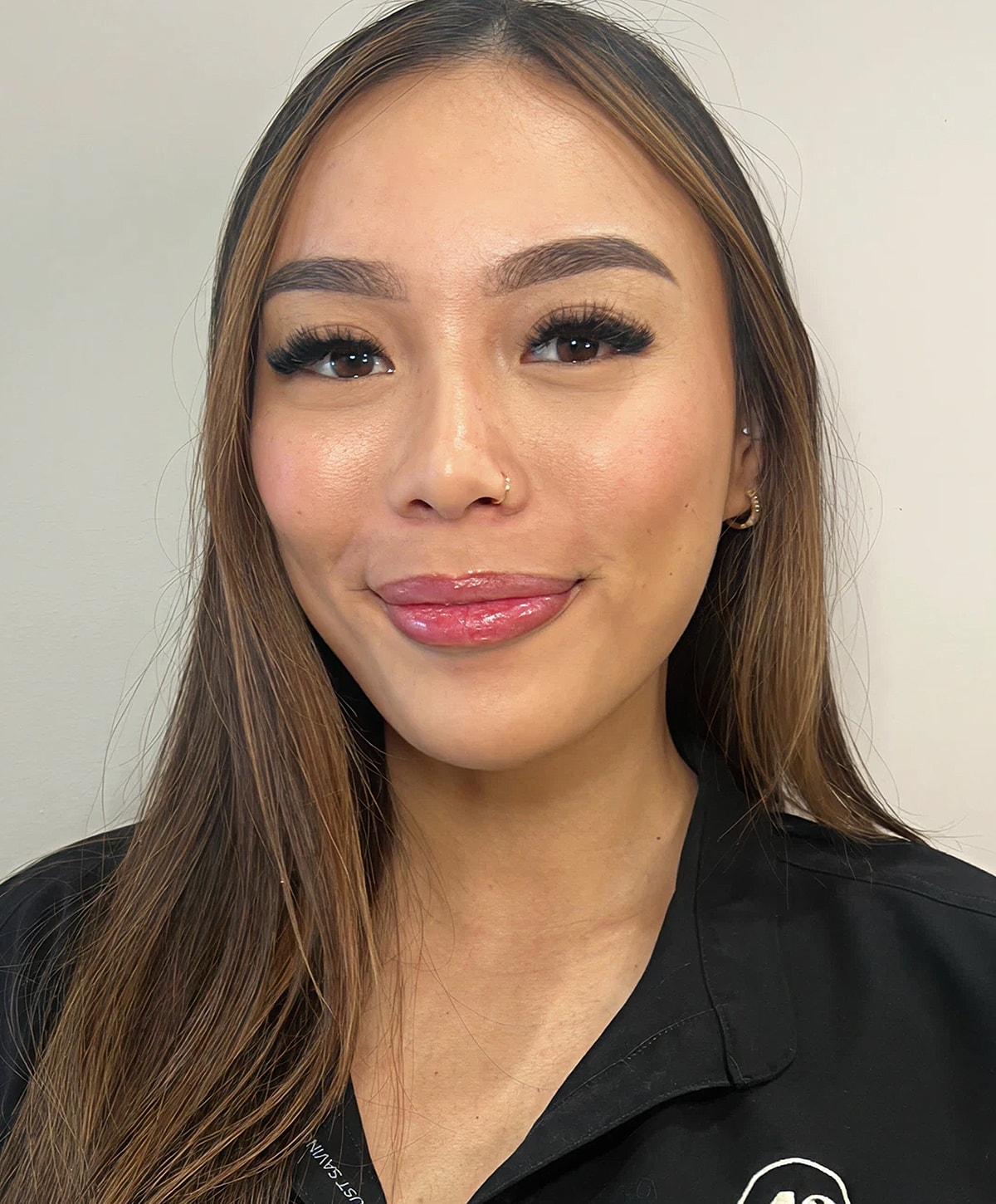 Smiling woman with long hair and natural makeup.