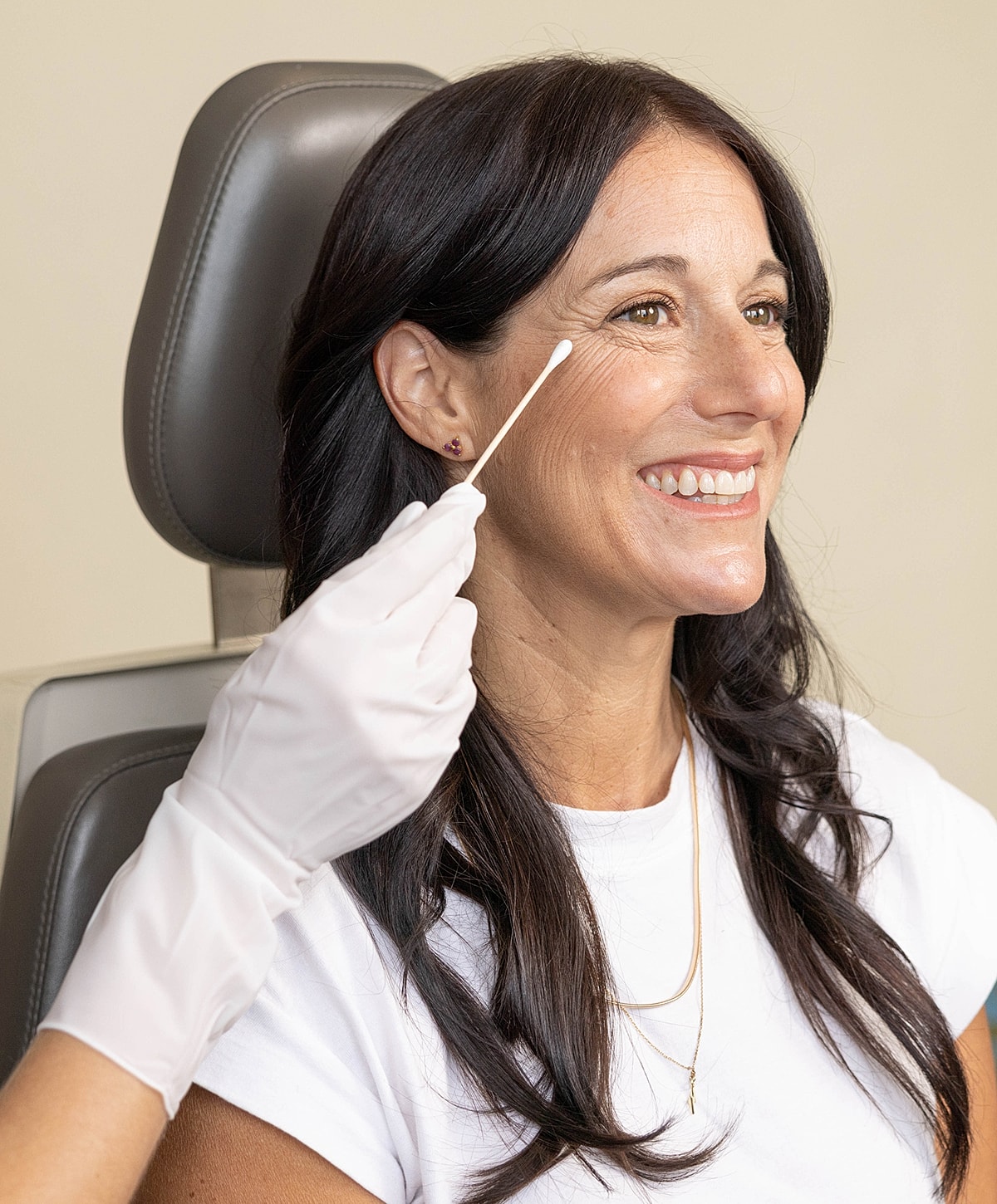 Woman smiling during a cosmetic procedure.