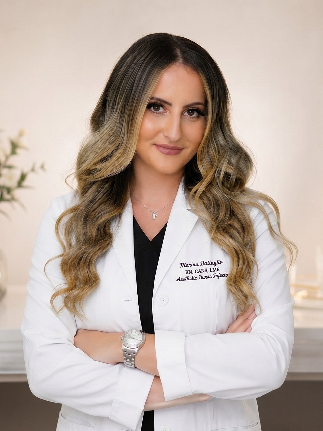 Female nurse in white coat, arms crossed.