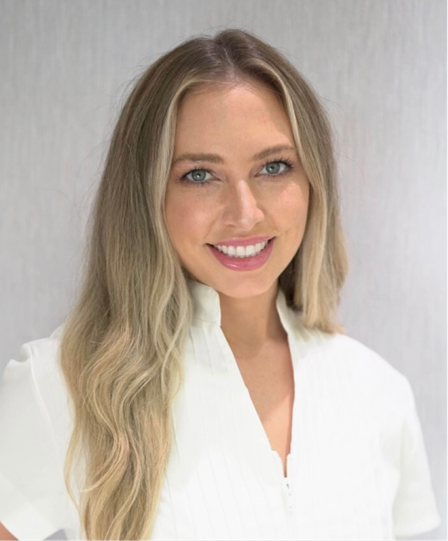 Smiling woman with long blonde hair in white top.