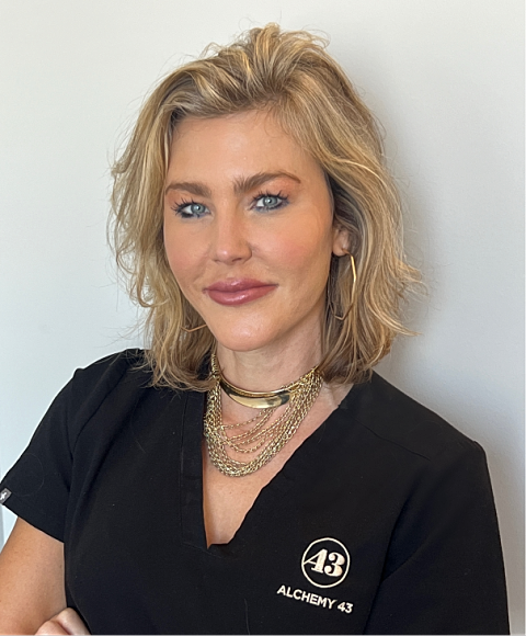 Smiling woman wearing a white blouse, light background.