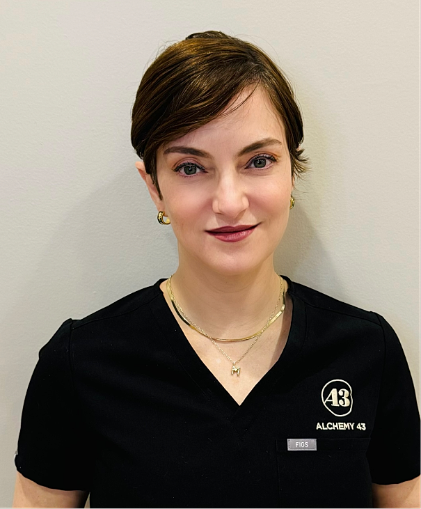 Professional woman in scrubs smiling at camera.