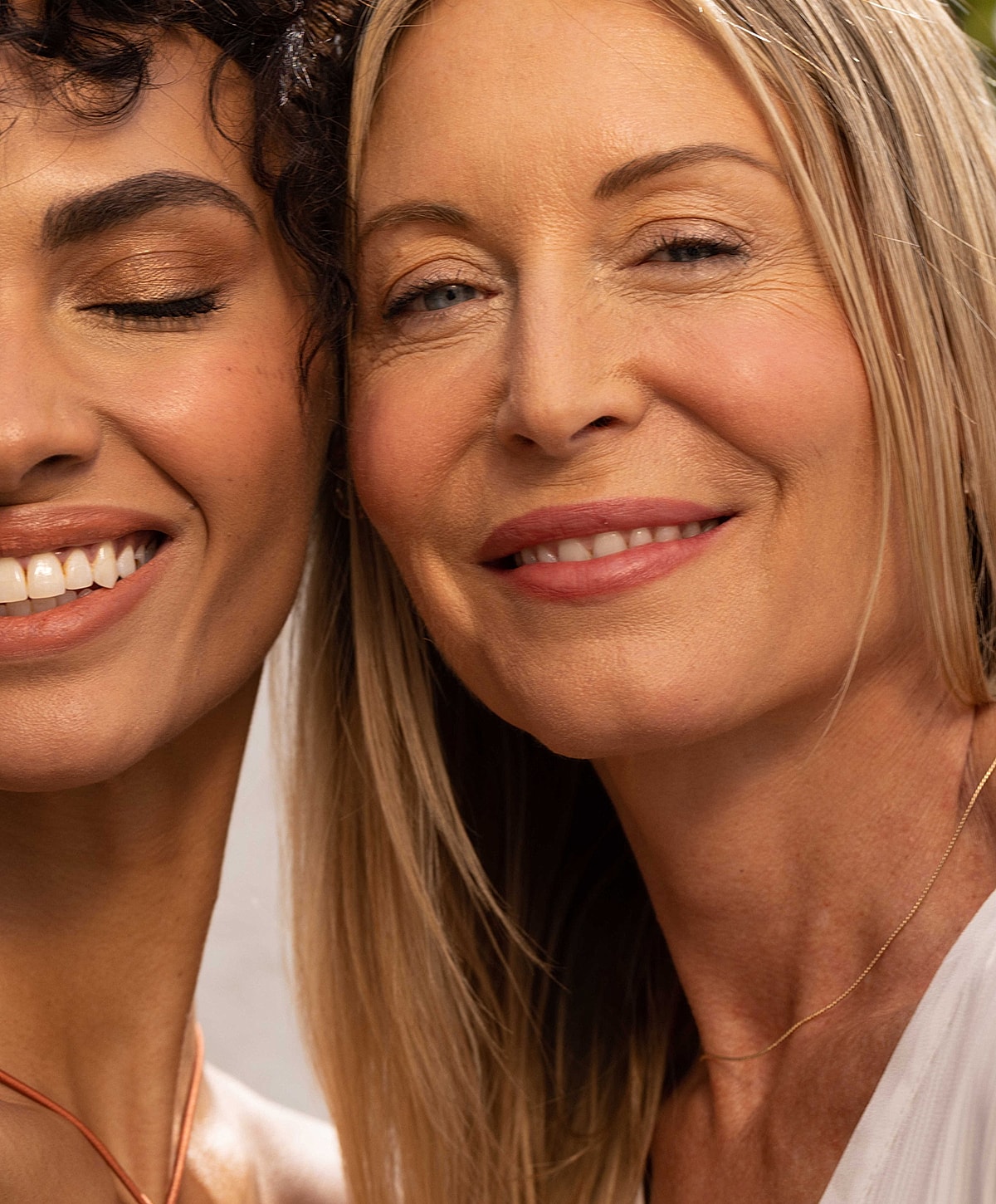 Two women smiling closely together.