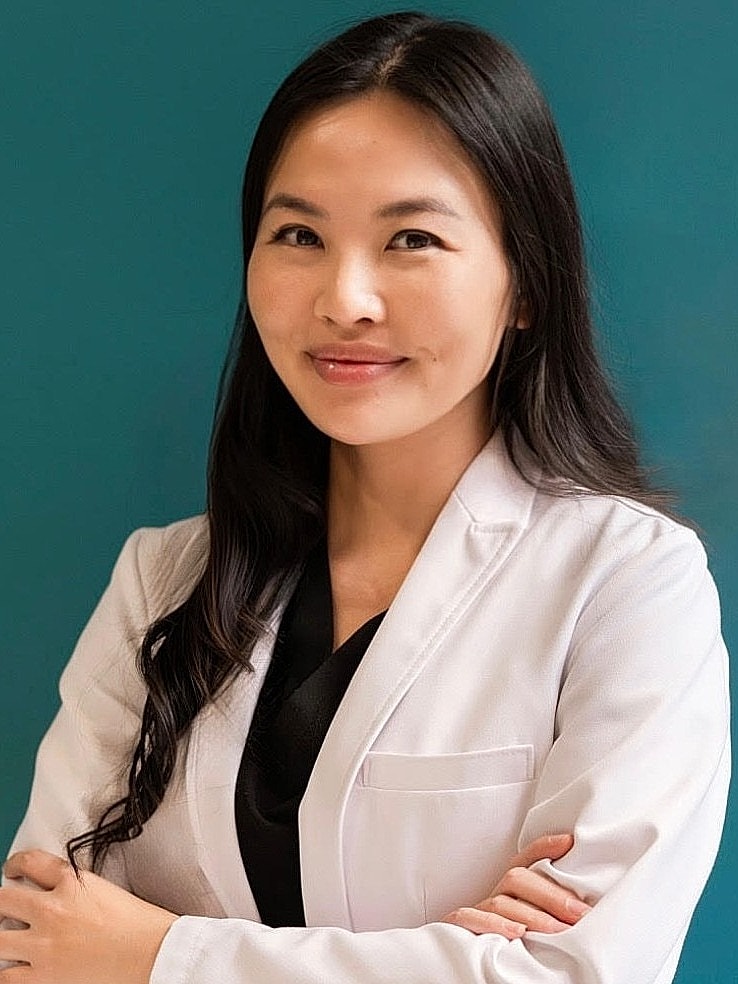 Female doctor smiling in a white lab coat.